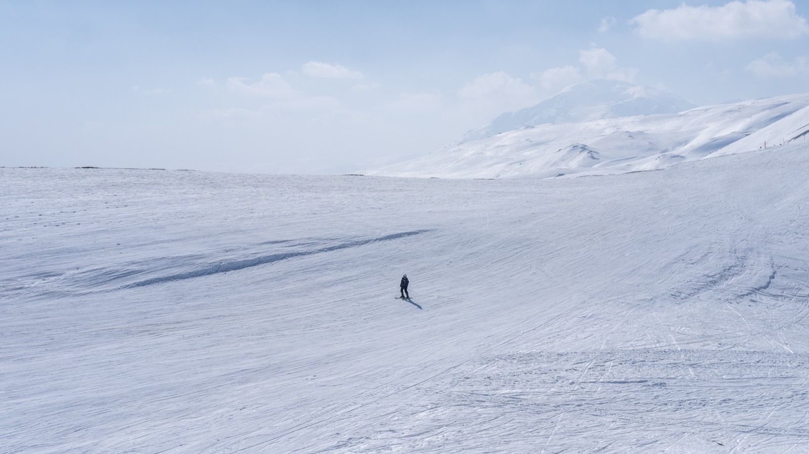 A single skier crossing an open slope